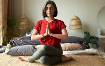 امرأة ترتدي قميصًا أحمر تمارس اليوجا